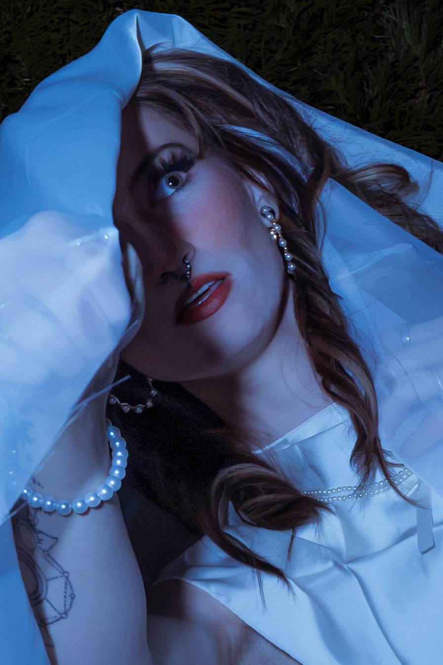 Artistic portrait series with flowing white fabric and pearl necklace against dark background.