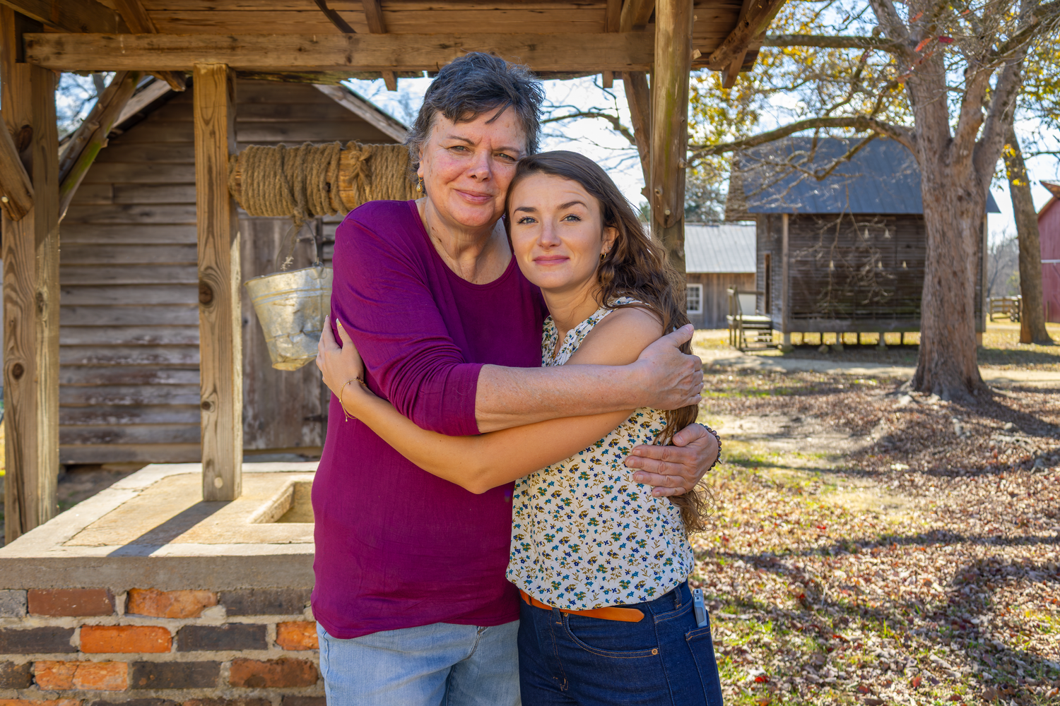 People sharing warm embraces on rustic wooden porch during fall season at Cedar Rock Park.