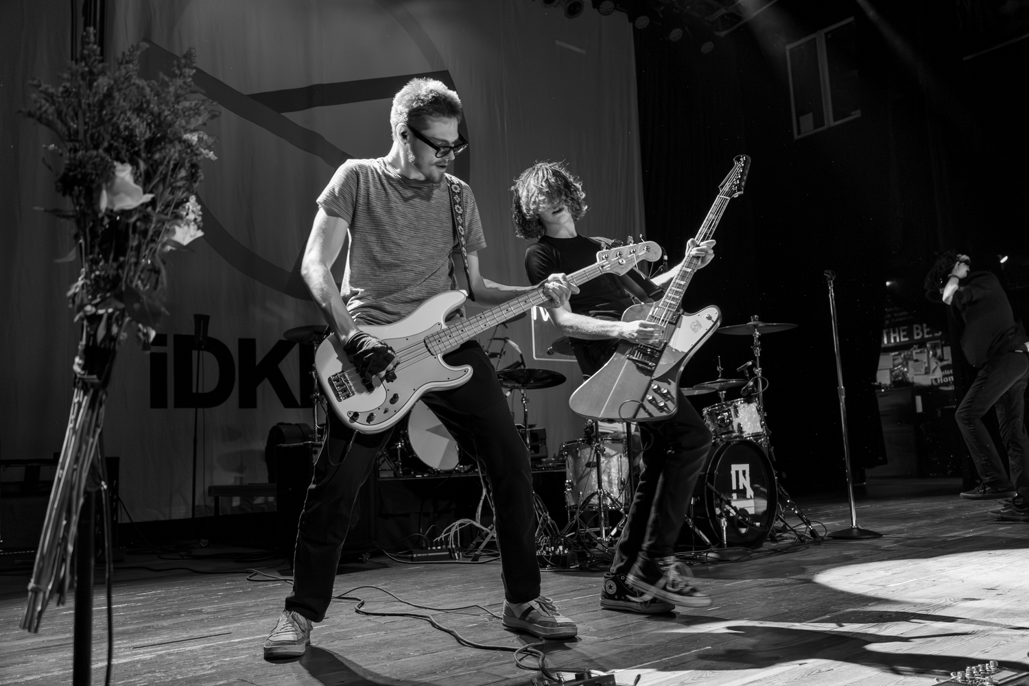Musicians with guitars captured in dramatic black and white stage photography.