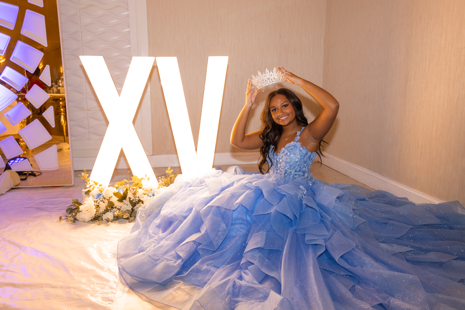 Quinceañera photos featuring flowing blue ball gown against white backdrop.