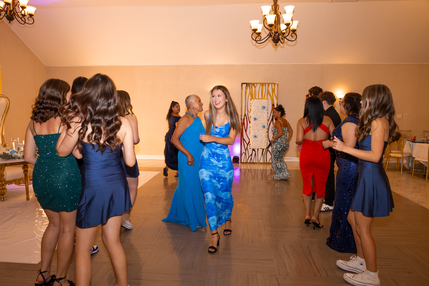 Quinceañera party members socializing and taking photos at reception venue.