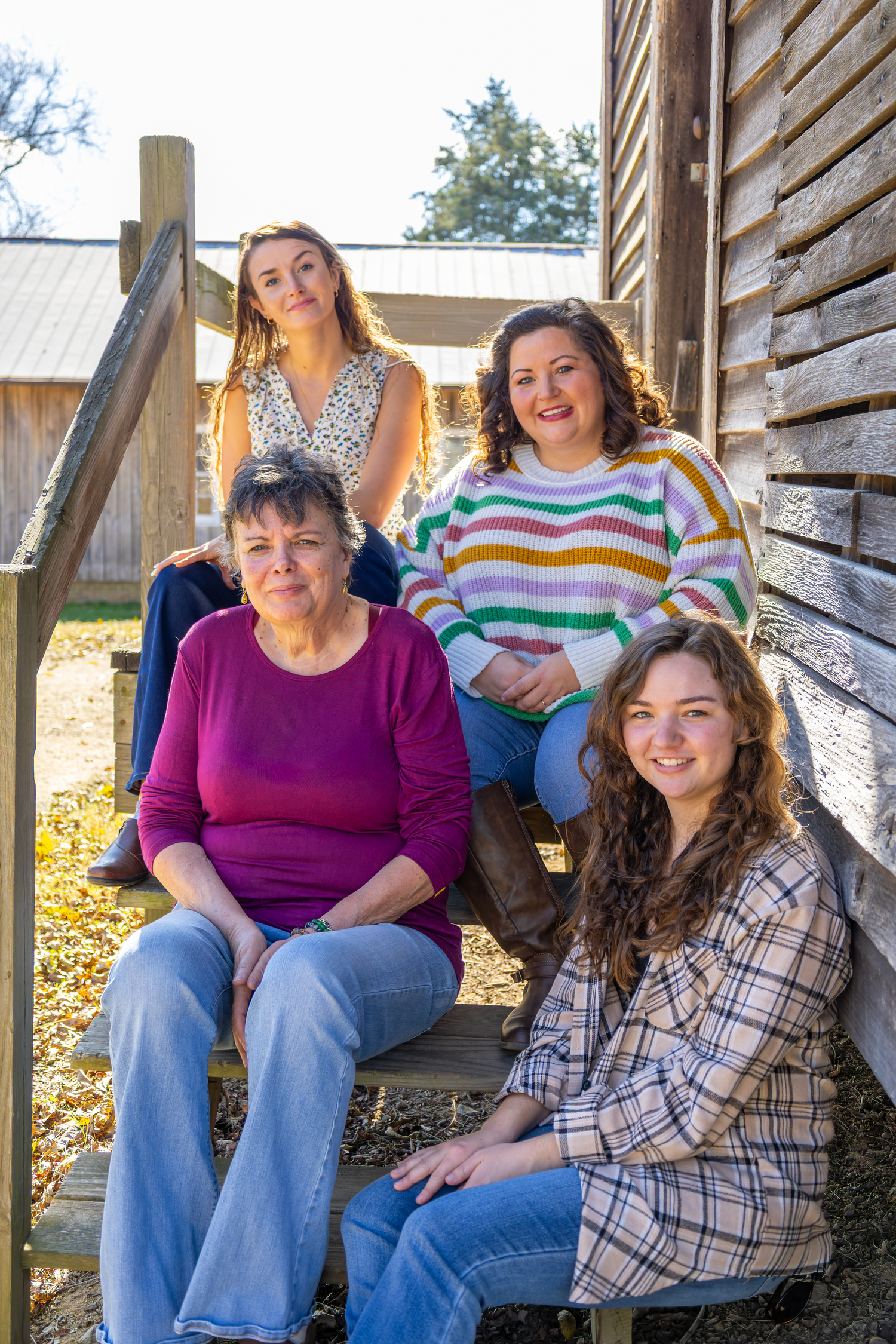 Group sitting together on wooden deck stairs during autumn afternoon at Cedar Rock Park.
