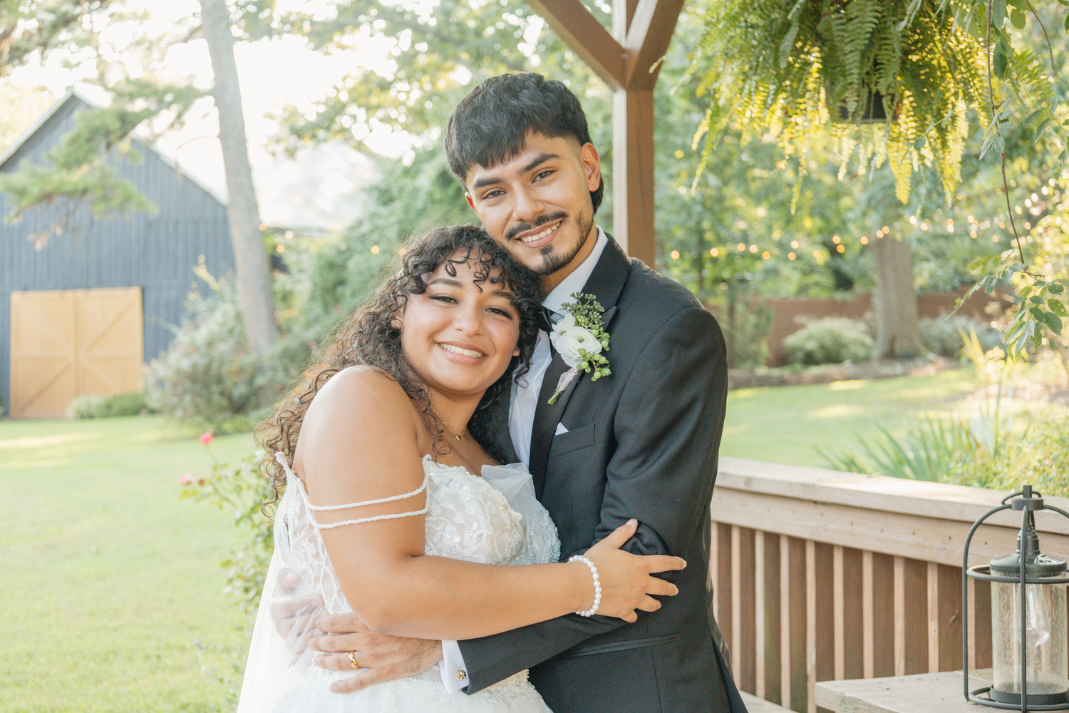 Newlyweds sharing intimate moments on a wooden deck surrounded by greenery at The Farmhouse Siloam.
