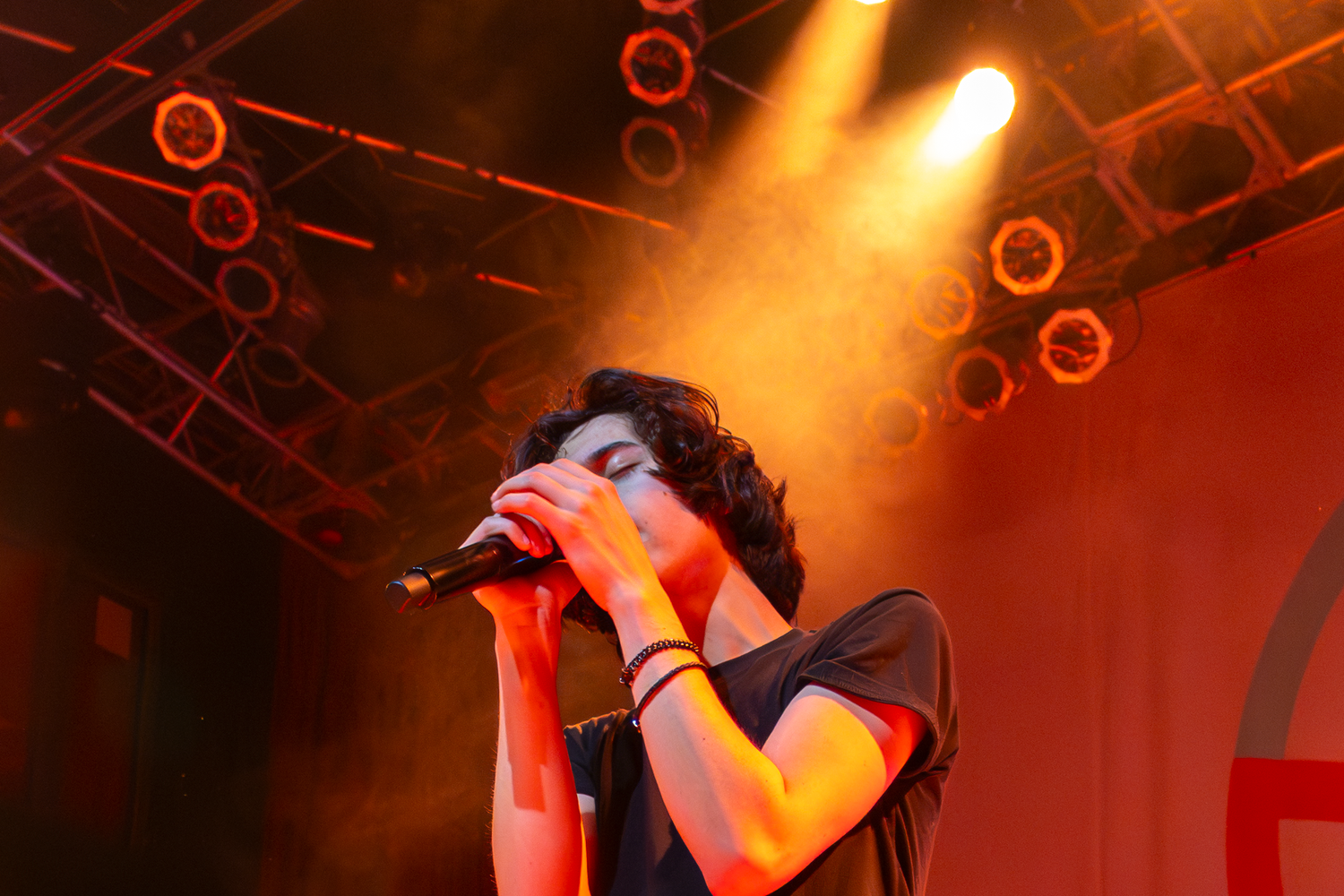 Concert performance lit with warm orange stage lights creating dramatic silhouettes.