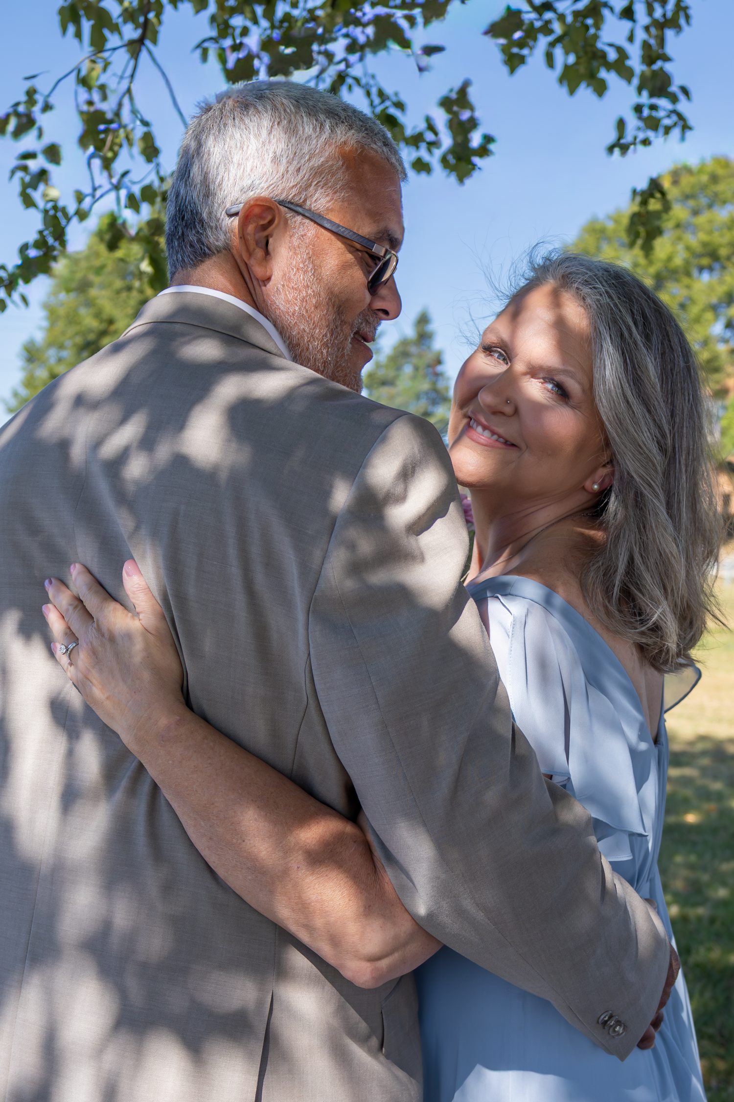 Romantic outdoor wedding photos showing tender moments between a couple in natural lighting.