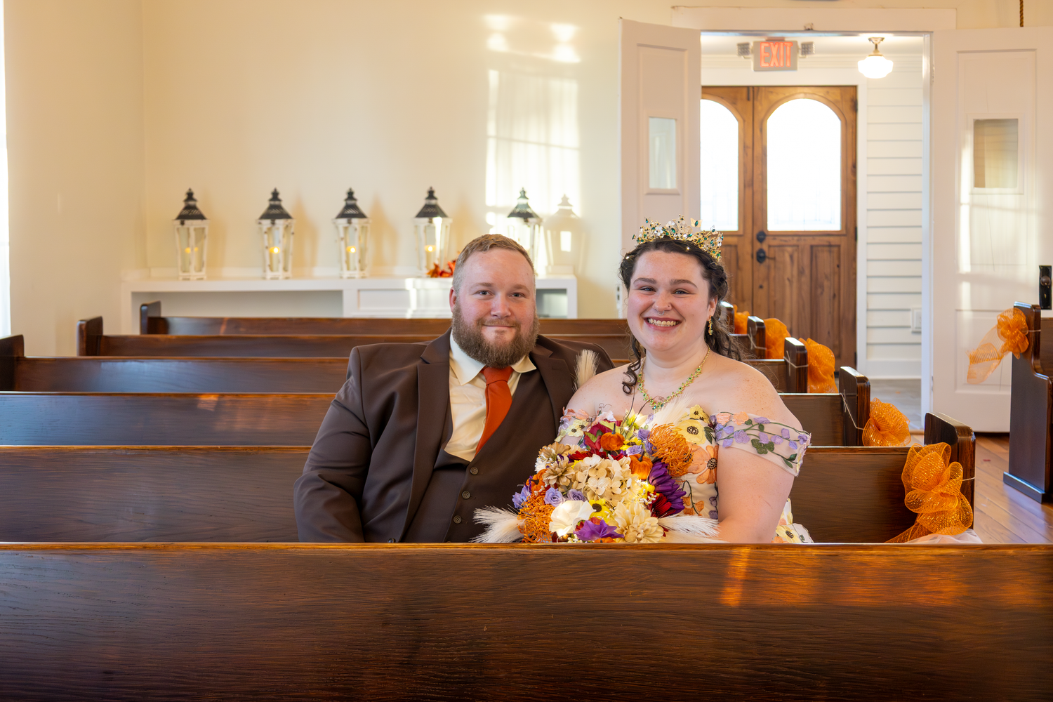 Wedding ceremony venue interior with wooden pews and warm lighting.