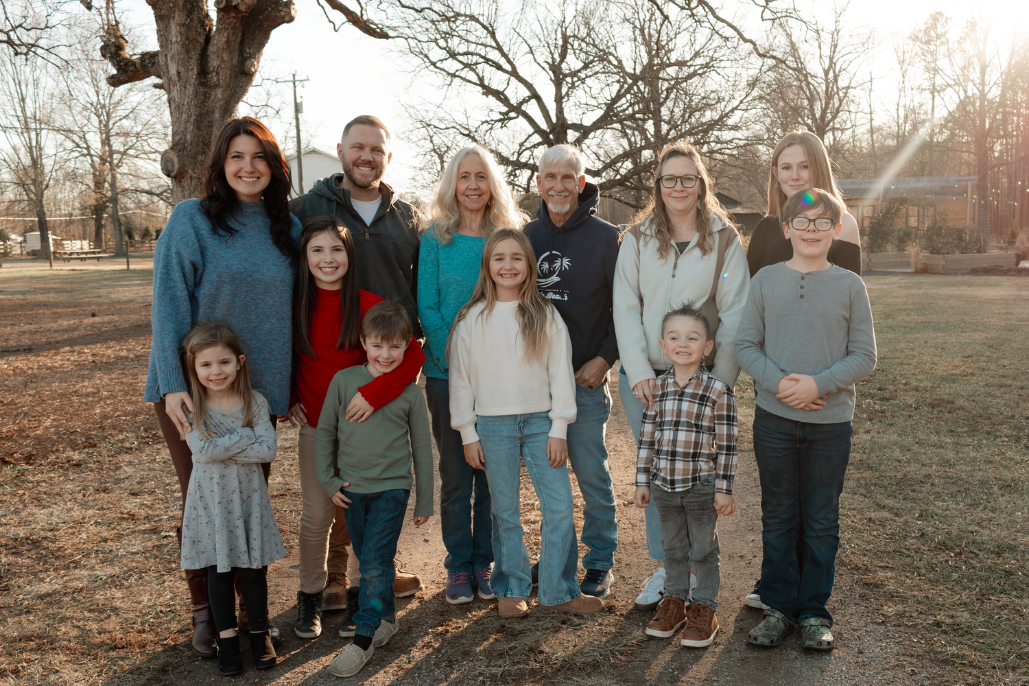 Group portrait taken outdoors at sunset with bare trees in the background at Oak Leaf Acres Farm.
