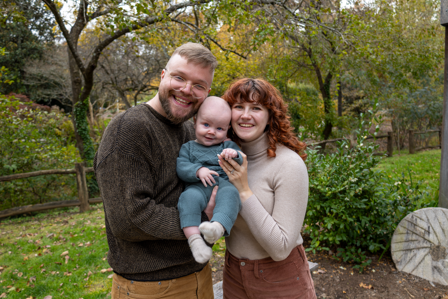 Outdoor family photoshoot in a natural park setting during fall season at Tanger Family Bicentennial Garden.