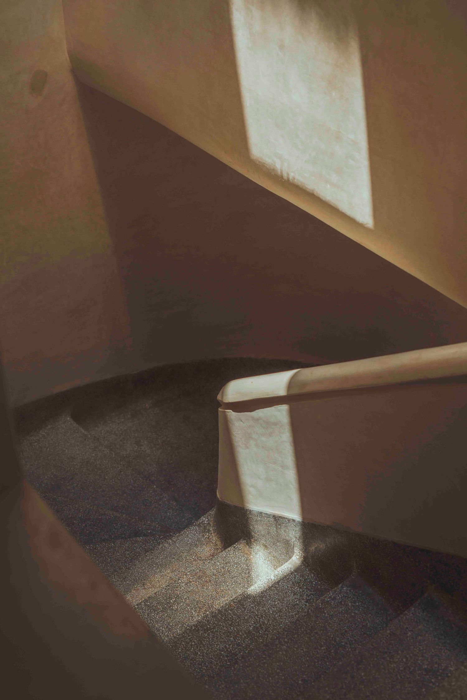 Geometric shadows cast on beige walls in modern architectural space.