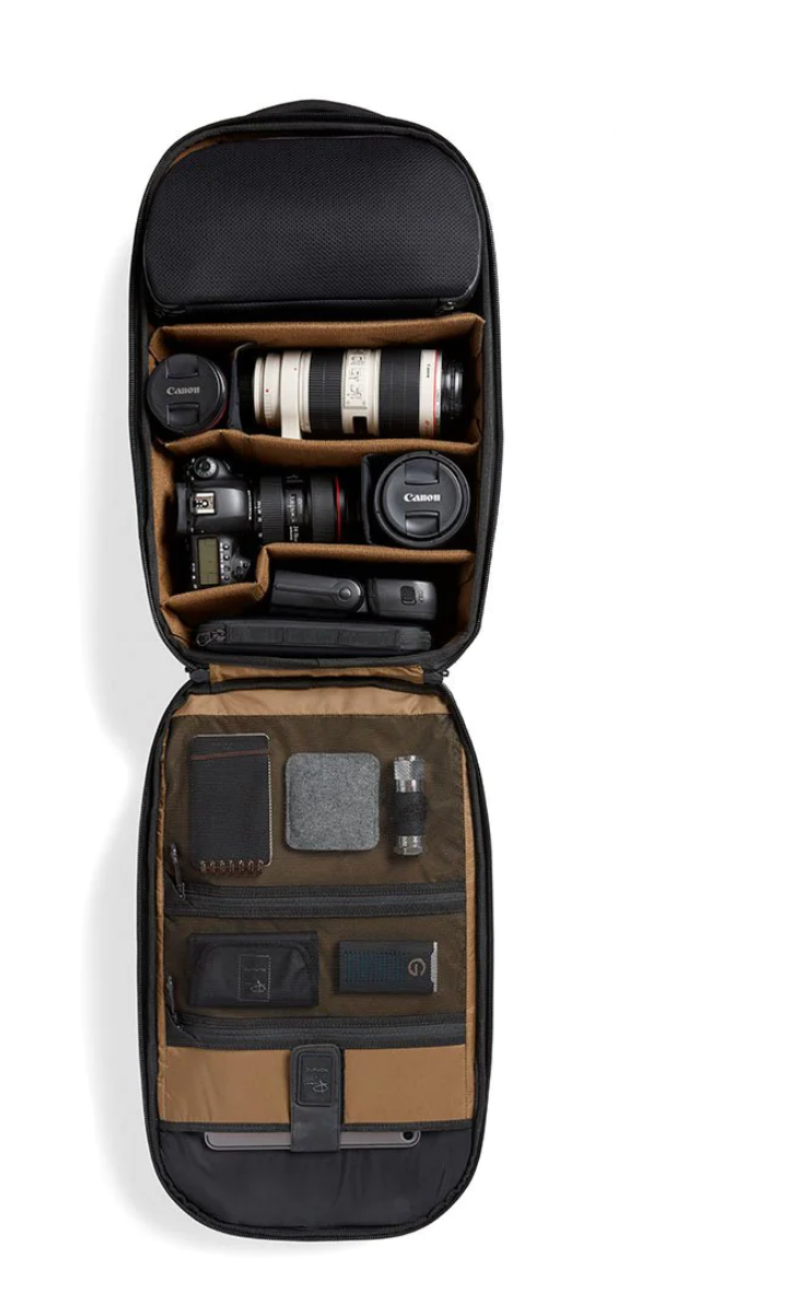 Open camera backpack showing organized compartments with lenses and photography equipment.