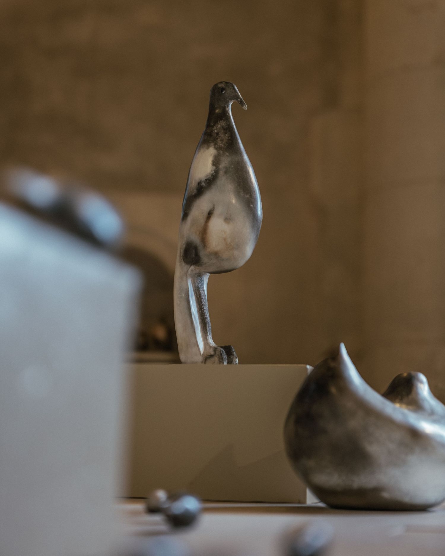 A set of dusty tan ballet shoes lined up on a wooden surface in varying poses shows wear and character.