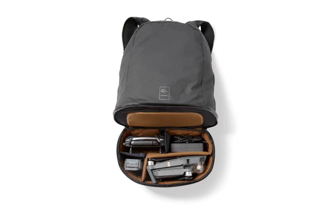 Open gray backpack revealing organized internal compartments with electronic accessories.