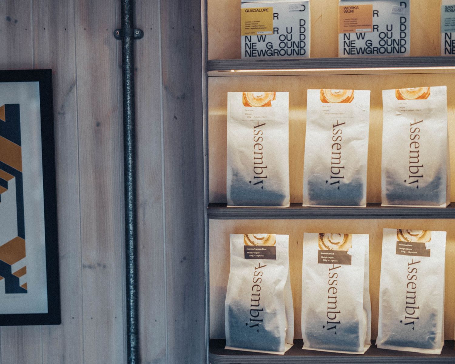 Row of uniform coffee bags displayed on illuminated retail shelving.