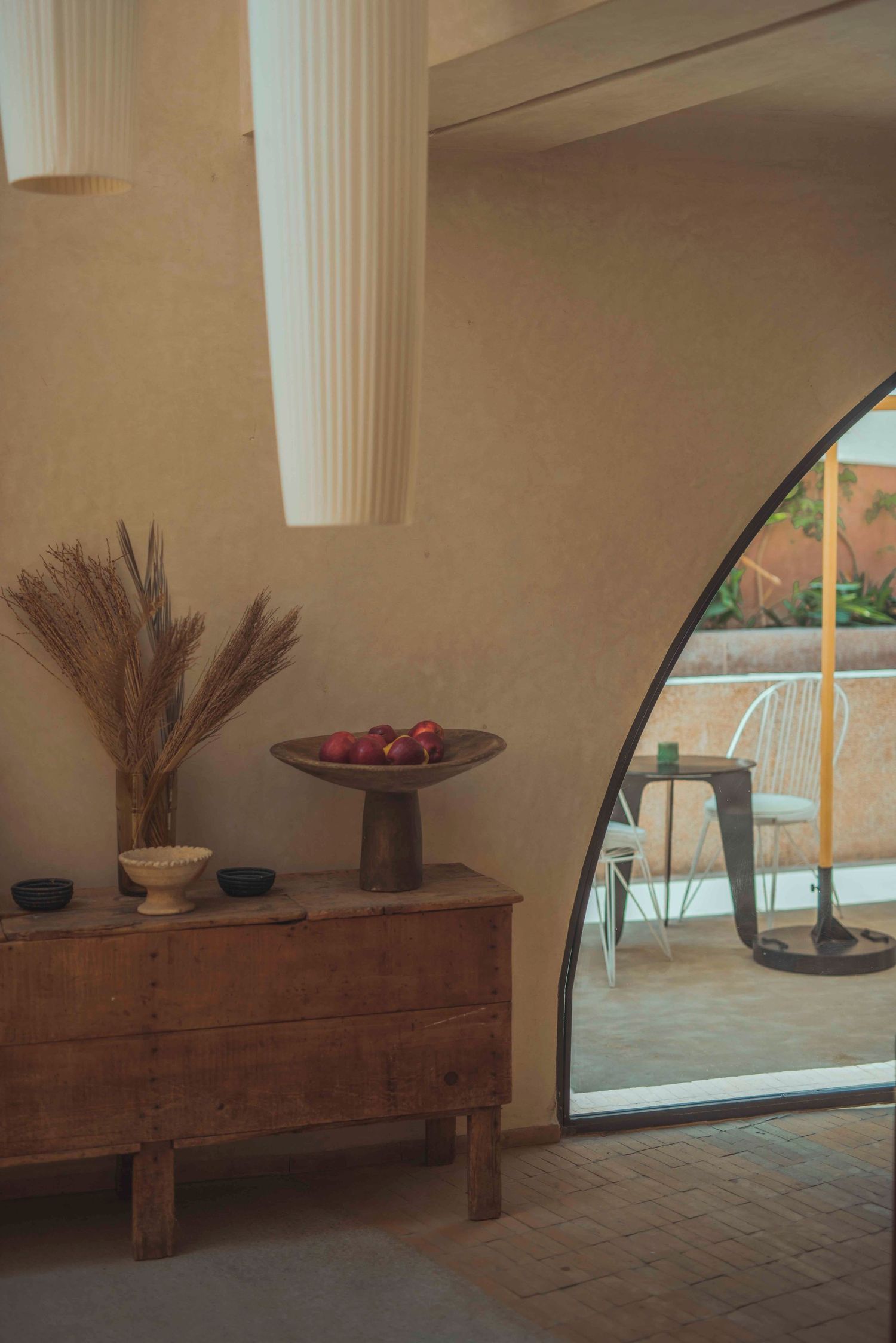 Interior design with arched doorway showing wooden console table and decorative elements.