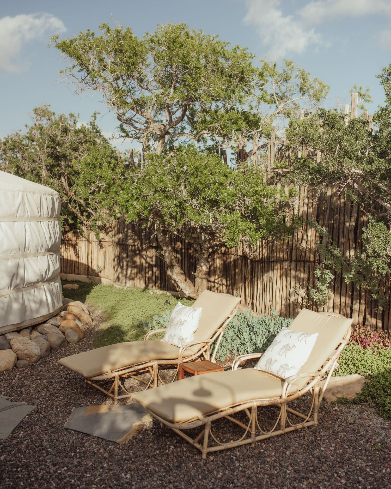 Outdoor lounge area with rattan chairs and desert landscape backdrop.