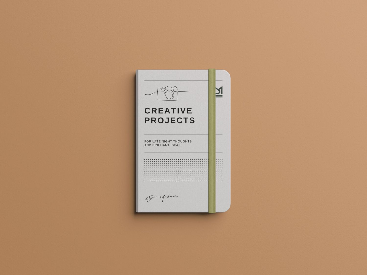 Creative projects notebook with elastic band closure on peach colored background.