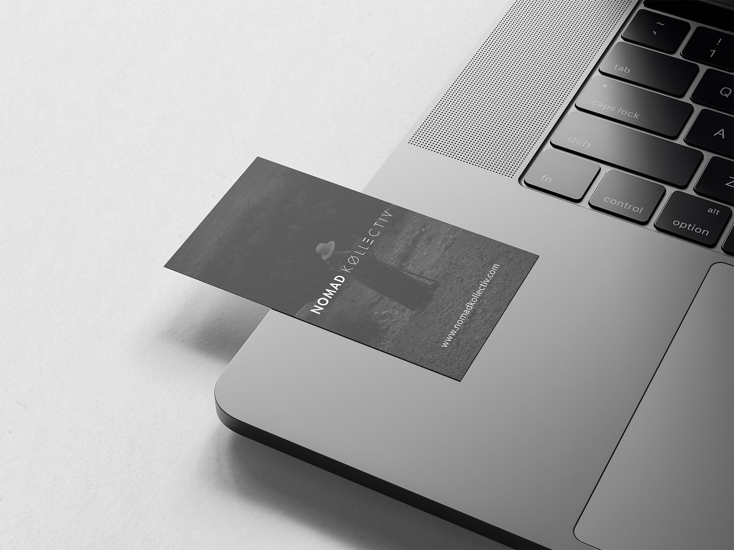Sleek laptop keyboard with metallic business cards arranged on surface.