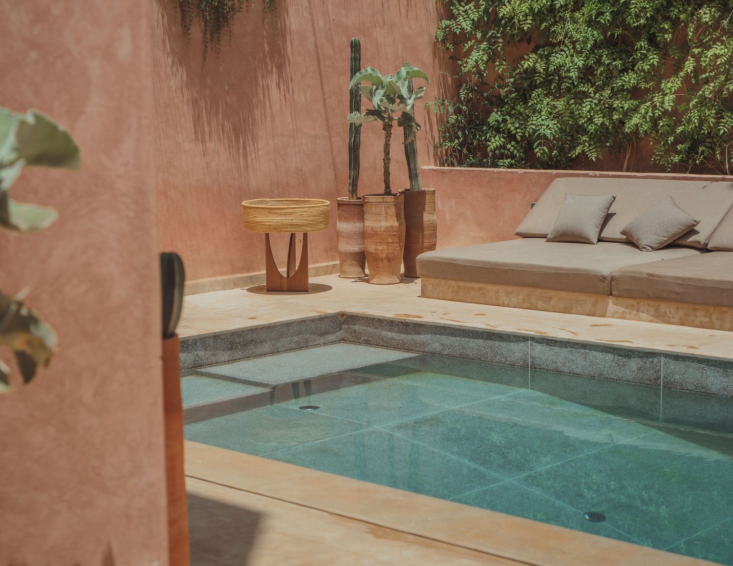 Luxurious terrace pool area with terra cotta walls and modern lounging furniture.