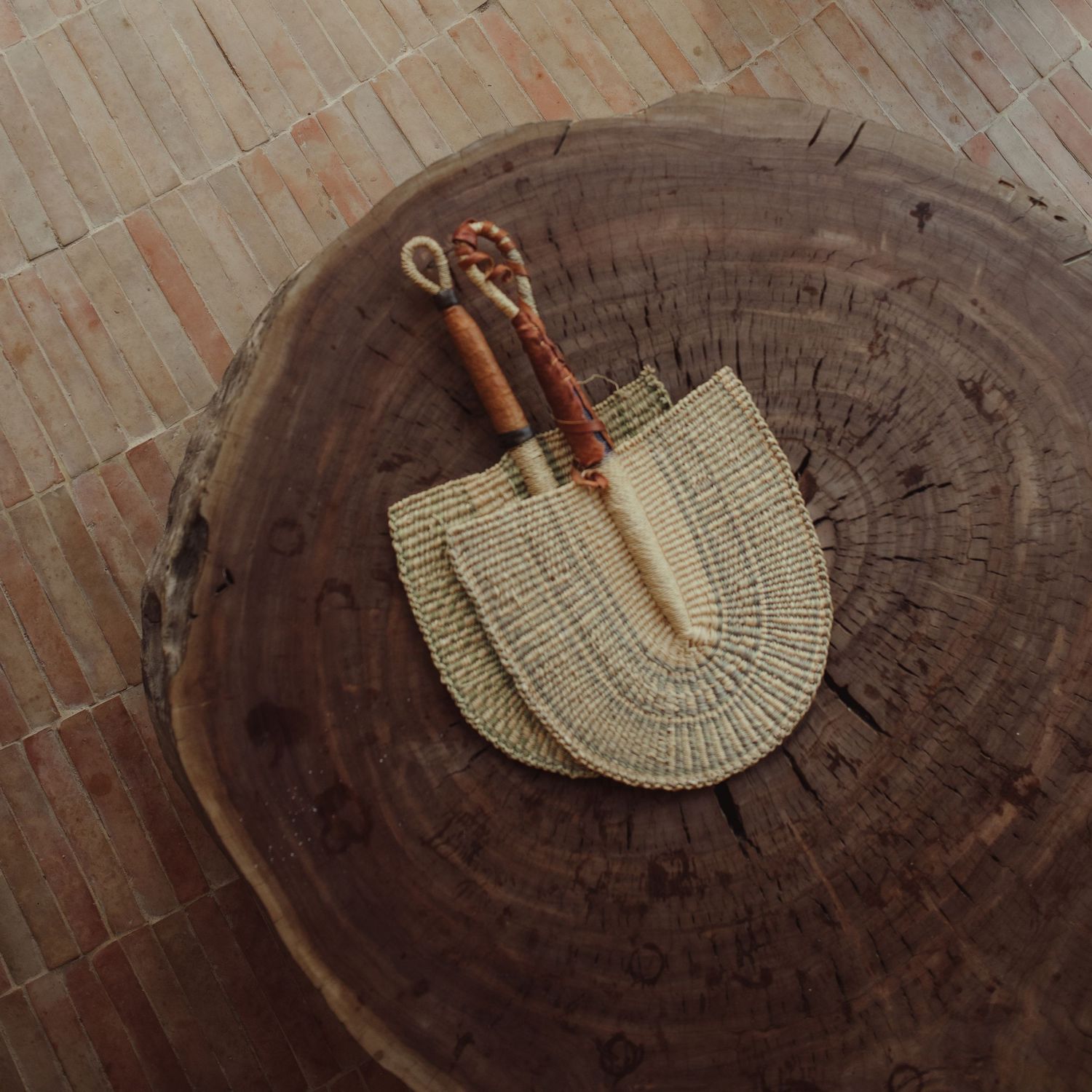 Knitting hook and yarn progressing across a wooden surface showing the process of crocheting in chronological steps.