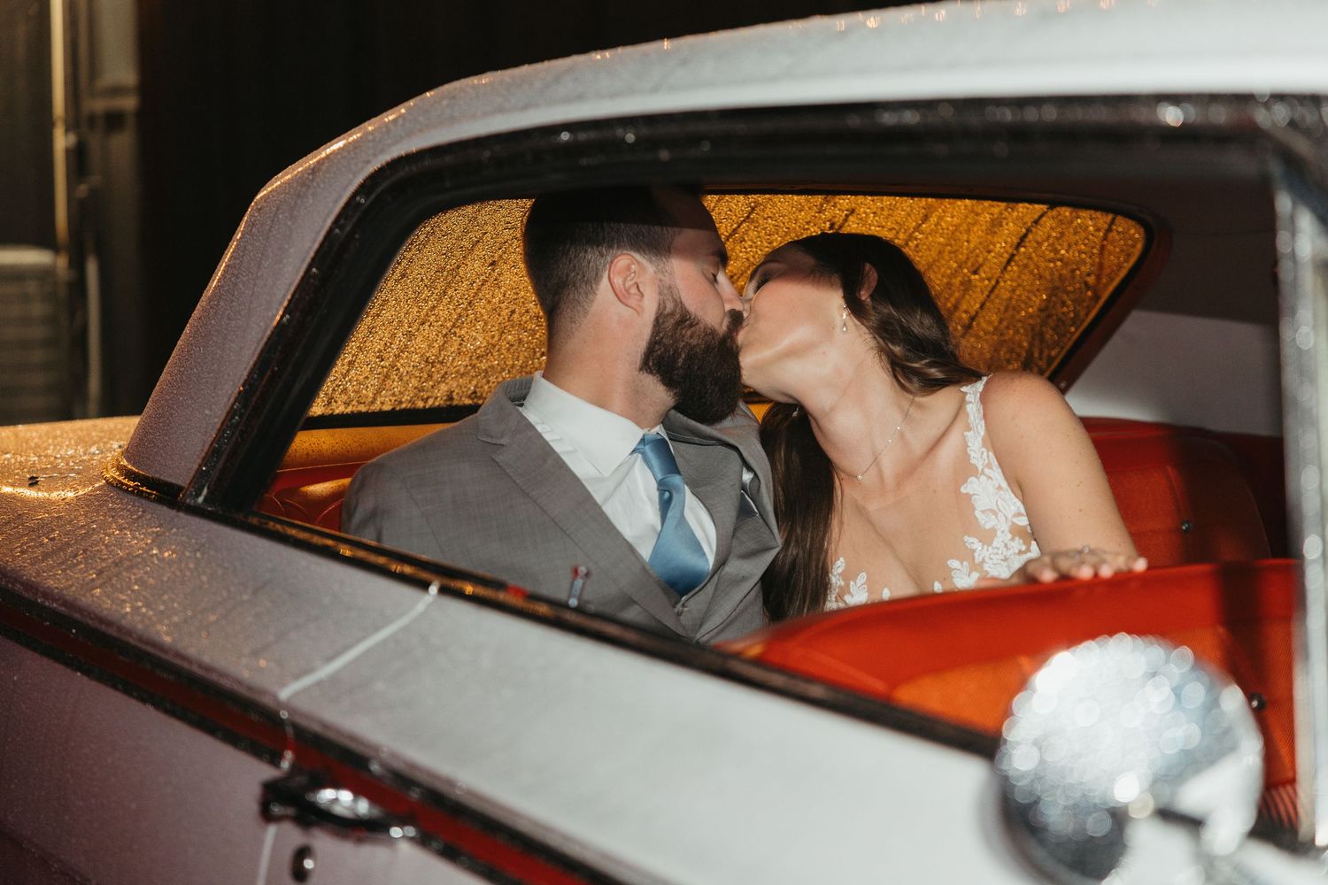A romantic moment captured between newlyweds in their getaway car.