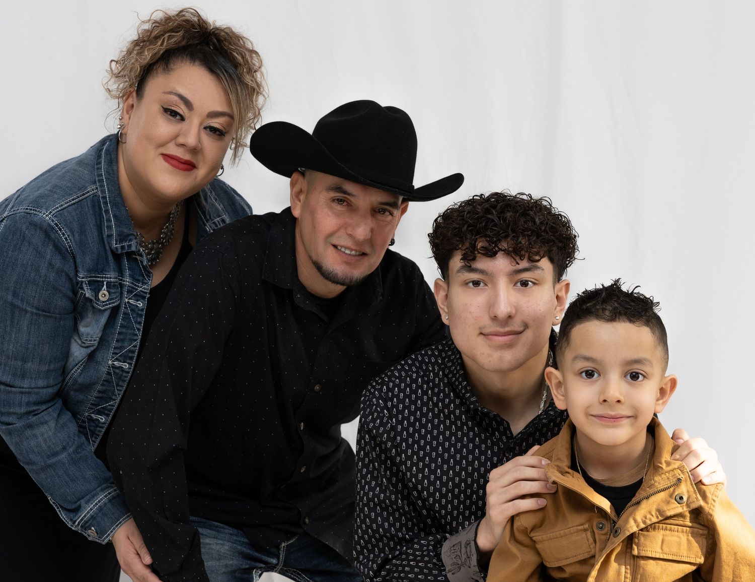 Studio portrait of a family group in casual attire against white background.