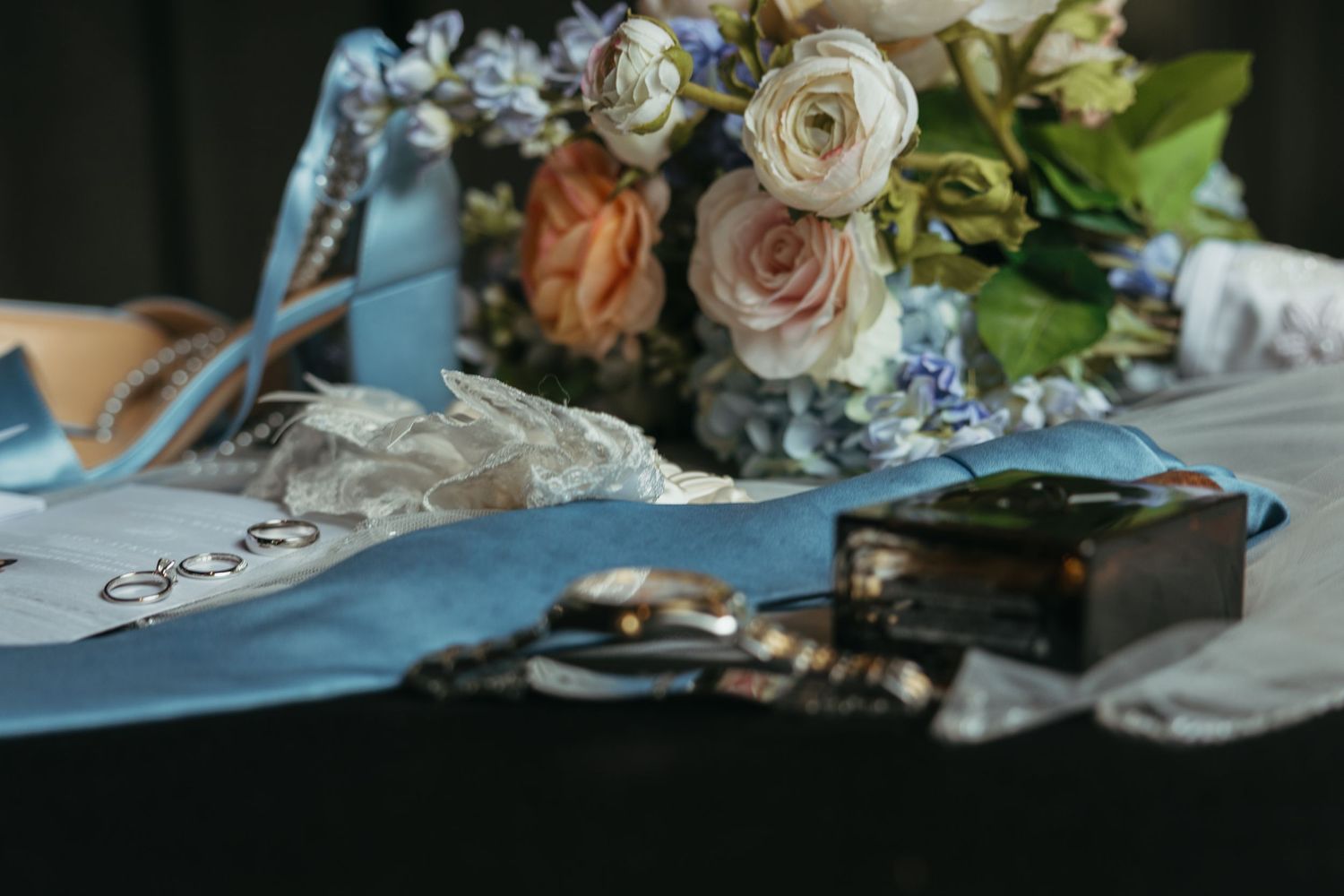 Soft pastel flowers and decor arranged on a table with muted lighting.
