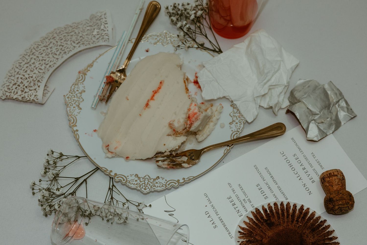 Wedding accessories including lace, delicate jewelry, and floral elements arranged on a white surface.