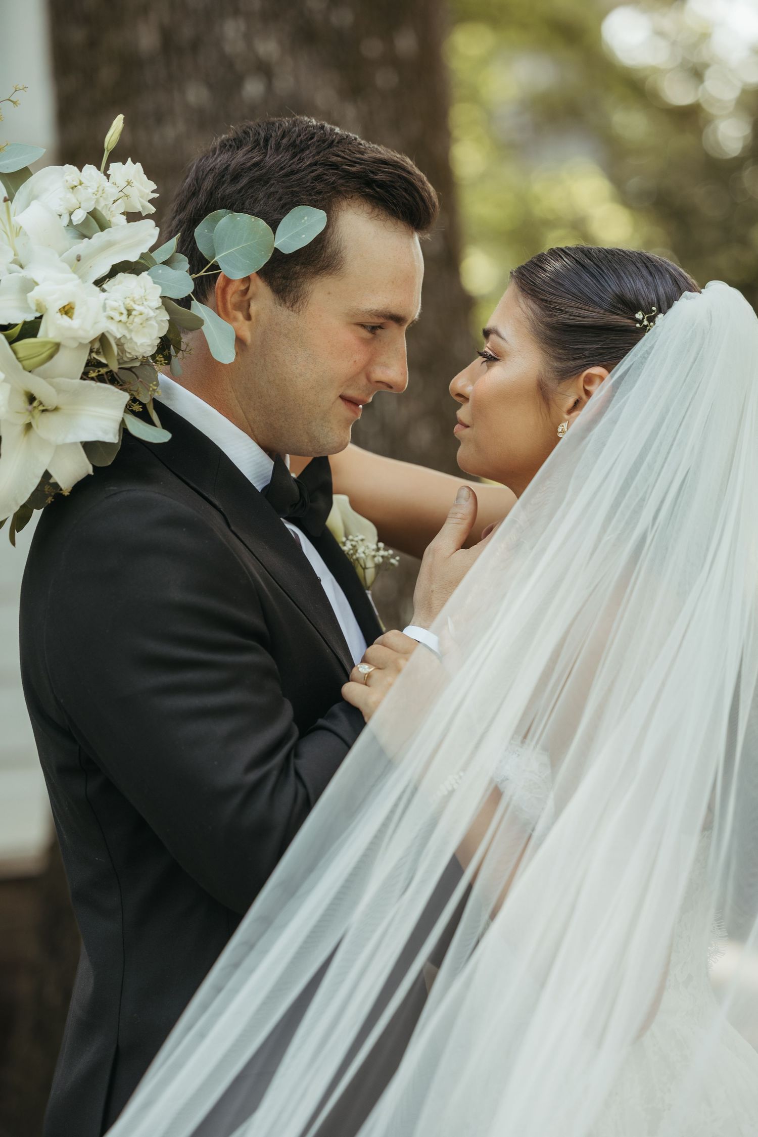 Intimate wedding portraits with a flowing veil in an outdoor garden setting.