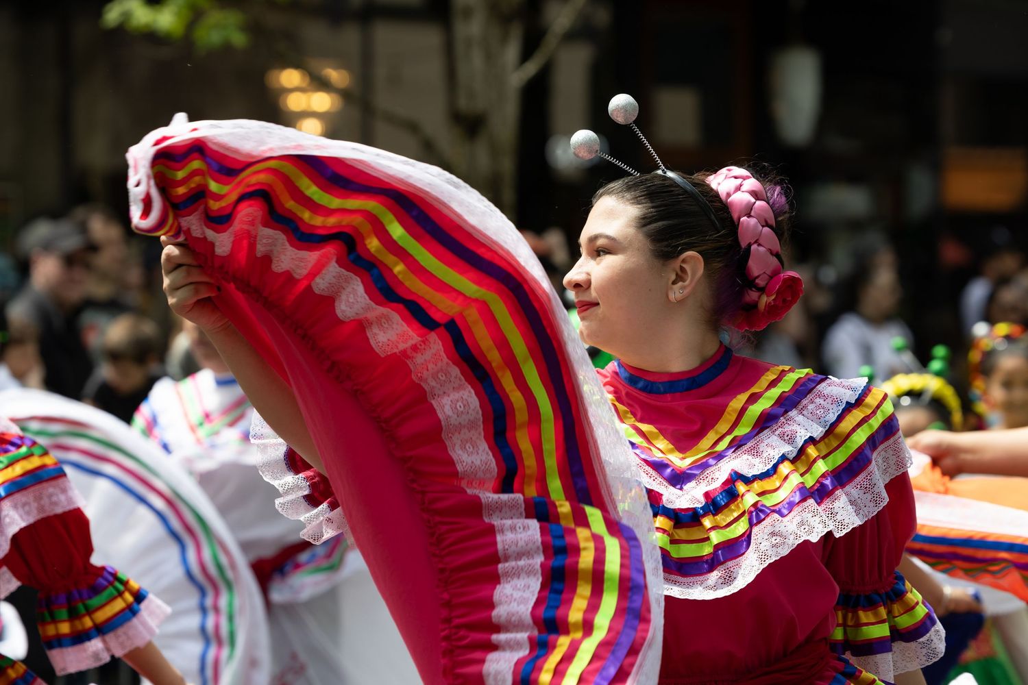 Traditional dancers in bright red and yellow ruffled dresses perform during a cultural celebration.