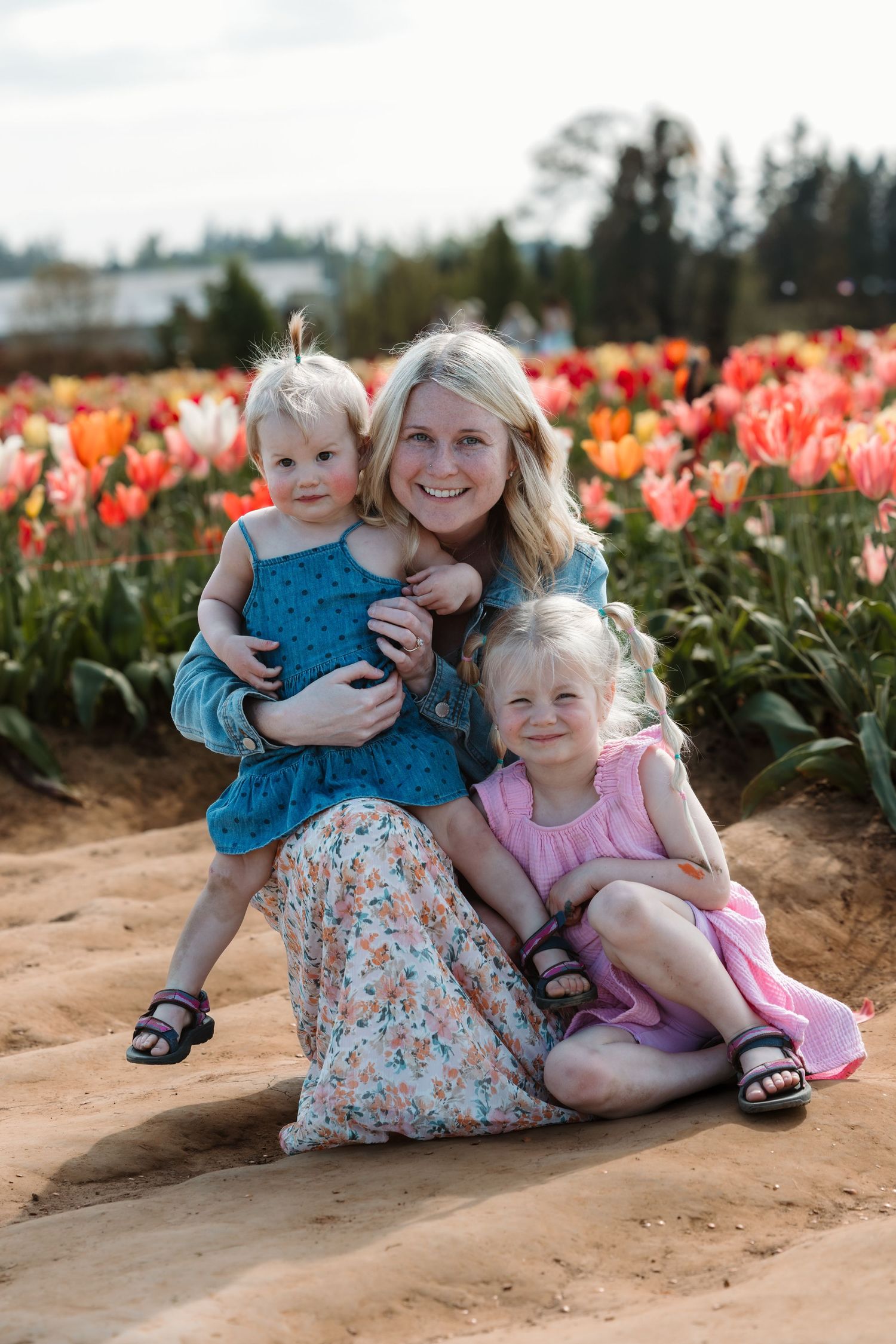 Family portrait in tulip garden with colorful flowers blooming in background.