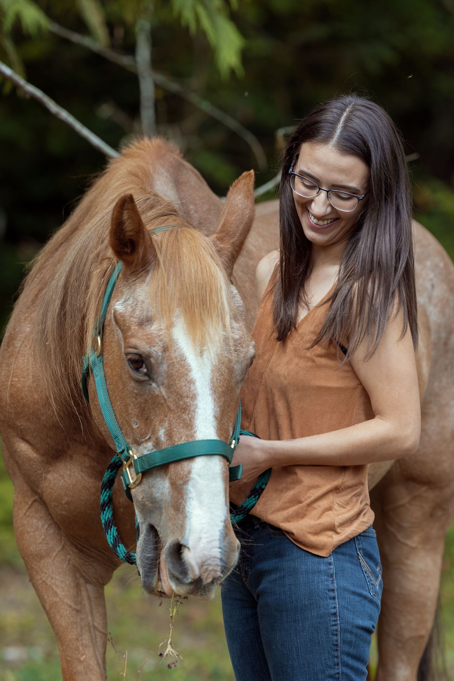 A series of photos showing a woman in a brown top bonding with her chestnut horse with a turquoise halter outdoors.