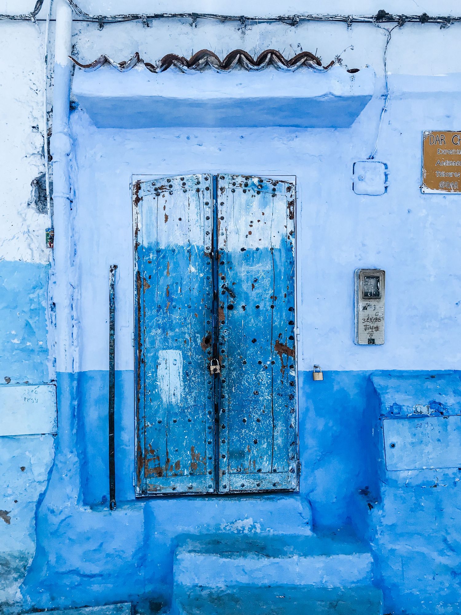 Weathered blue doors and walls create a monochromatic corridor in Chefchaouen's medina.