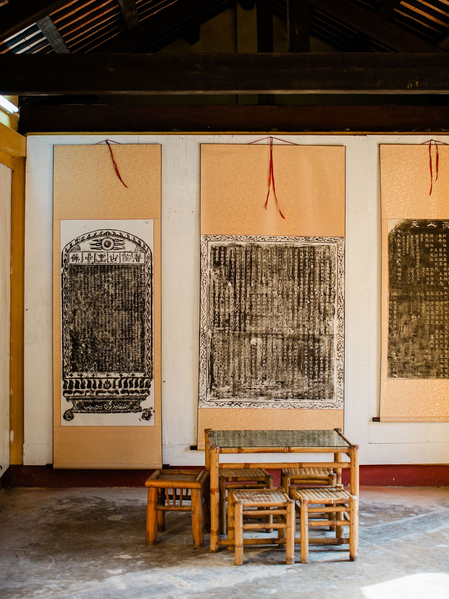 Traditional Chinese calligraphy scrolls displayed on wooden stands in a temple hall.