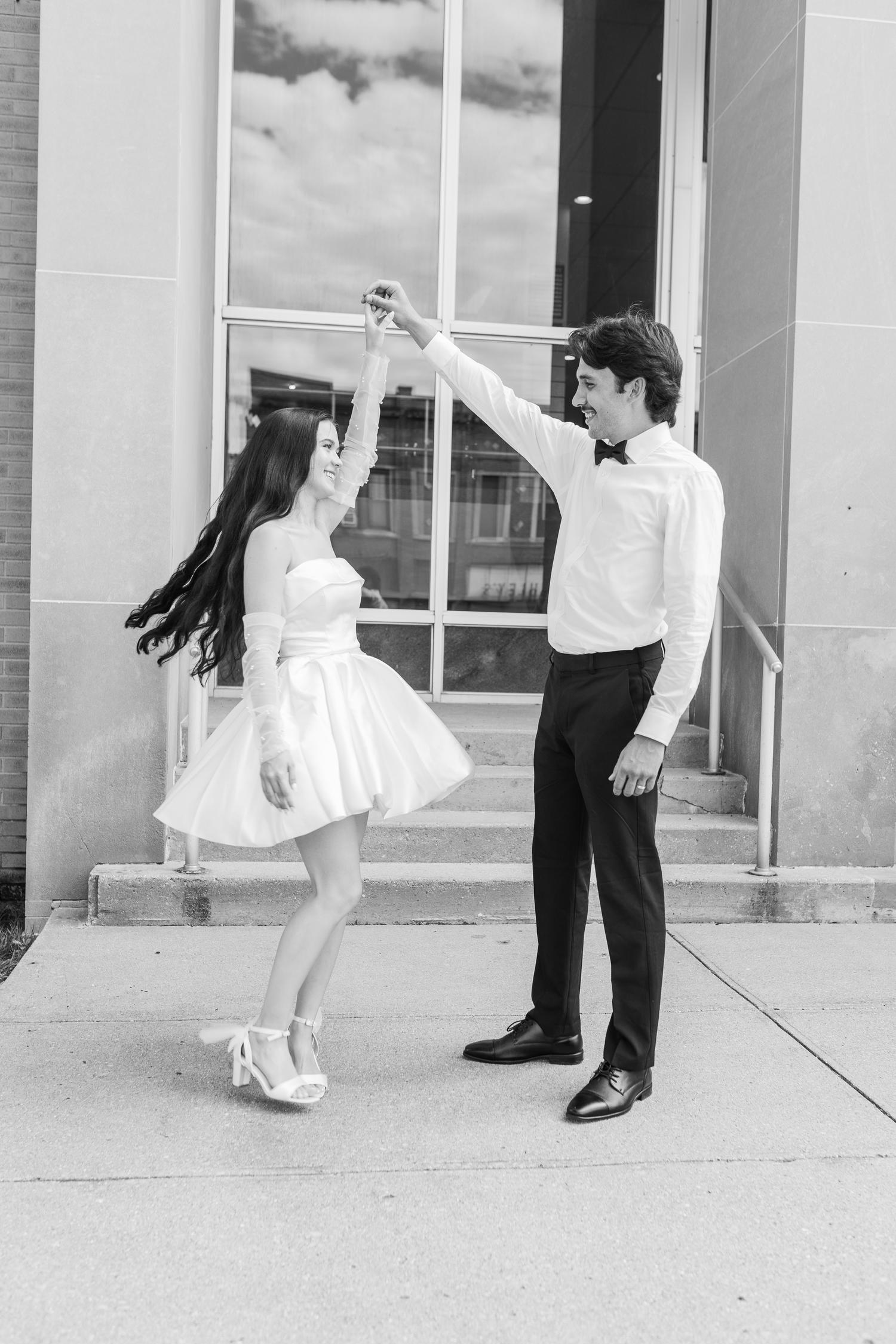 A couple dances together, courthouse, with the woman in a white dress twirling with the groom, in cass city, mid michigan photographer