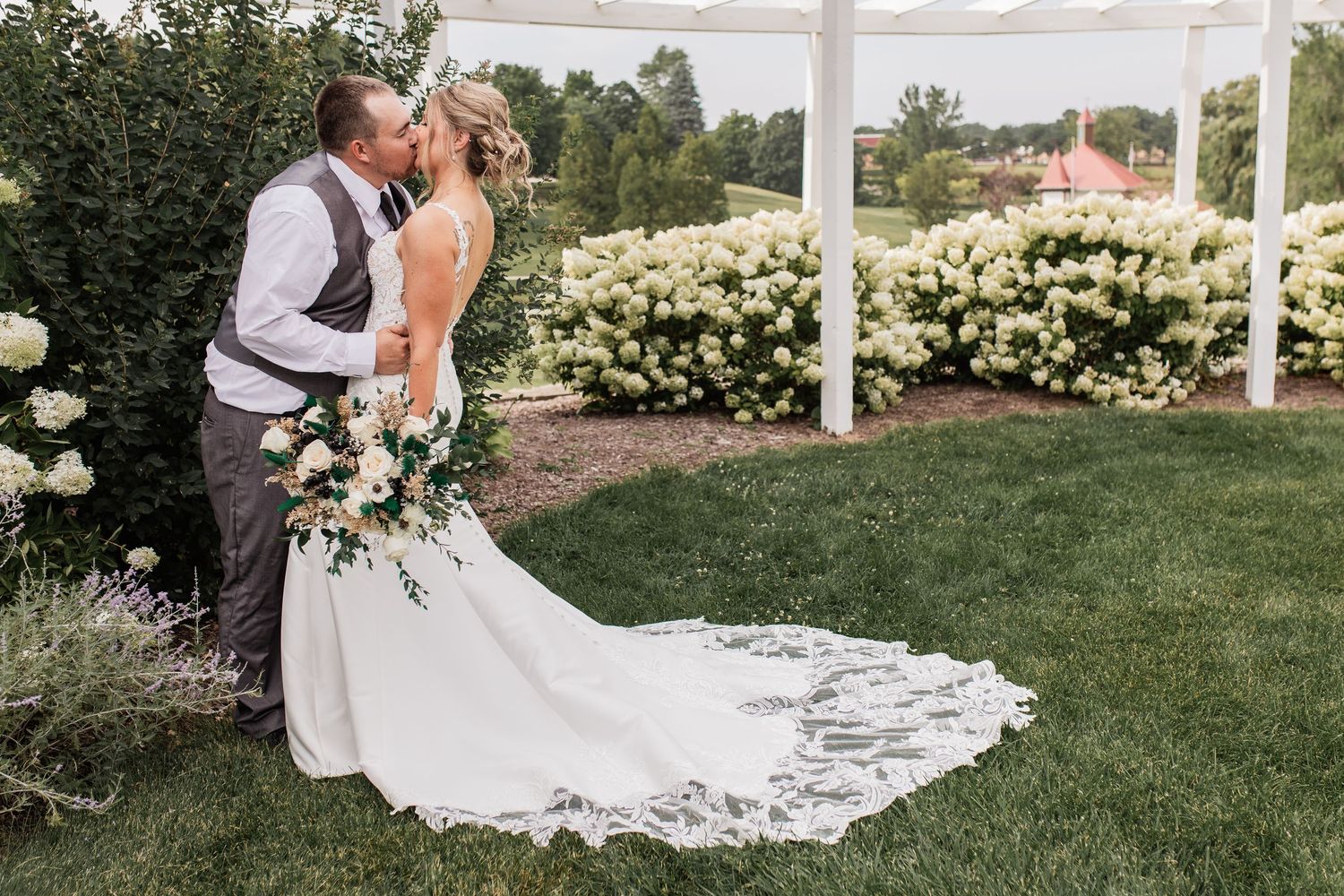 Bride and groom getting pre reception portraits done at rose garden in Frankenmuth Michigan b a local wedding photgrapher