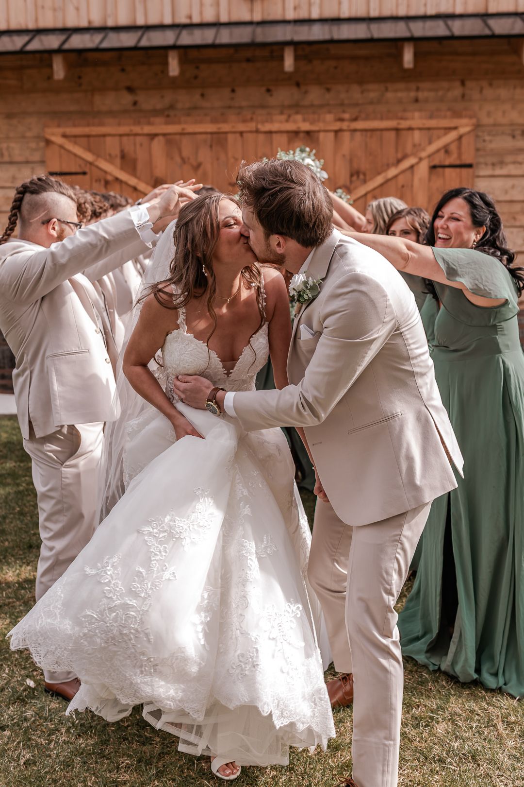 Wedding party and bride and groom getting portraits taken outside a local north branch michigan wedding venue at the Legacy Barn
