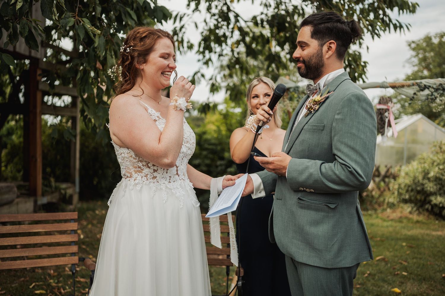 Bride and groom exchanging vows outdoors with officiant during an intimate garden wedding ceremony.
