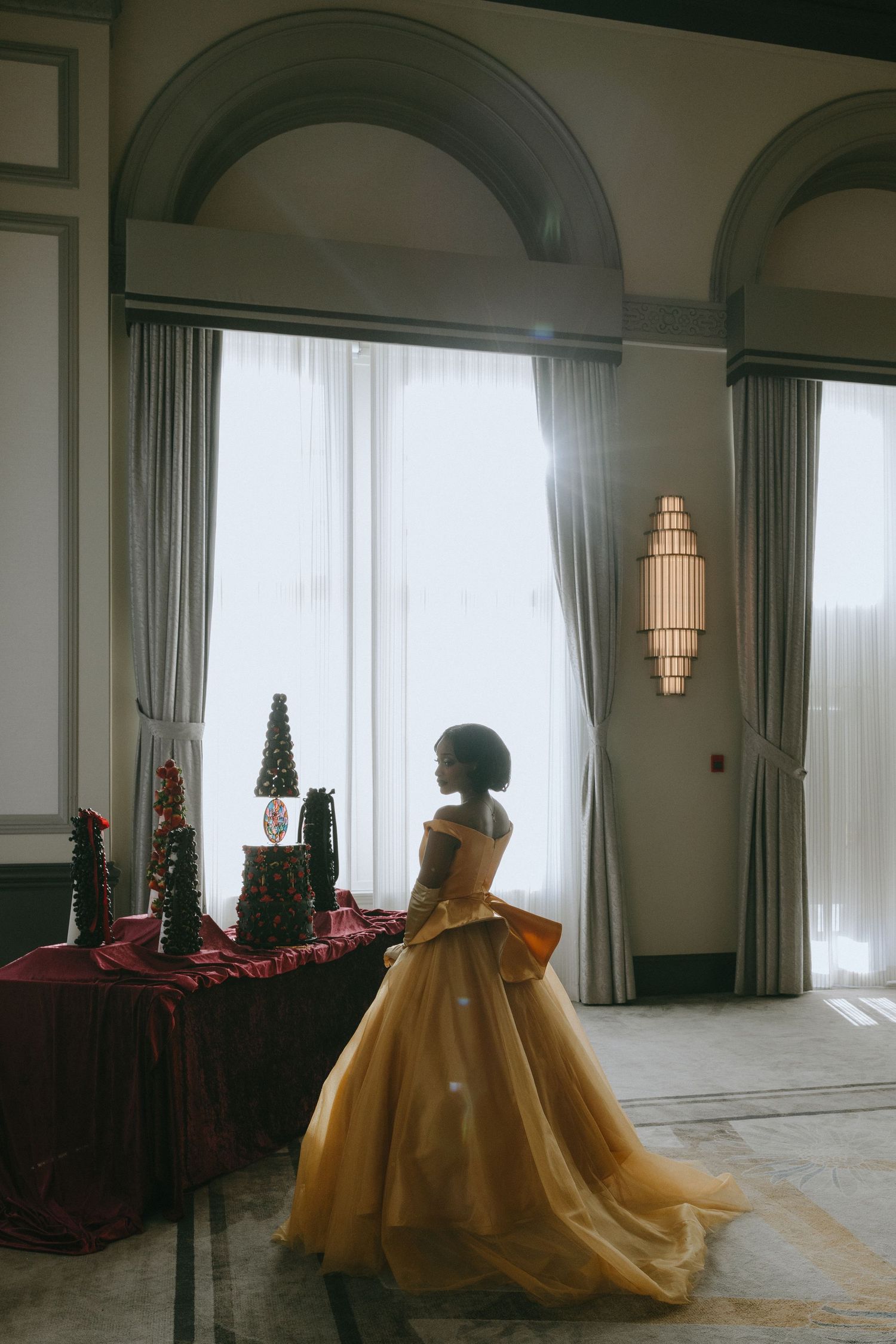 A series of connected photos showing a golden ball gown in an elegant room with arched windows and holiday decorations.