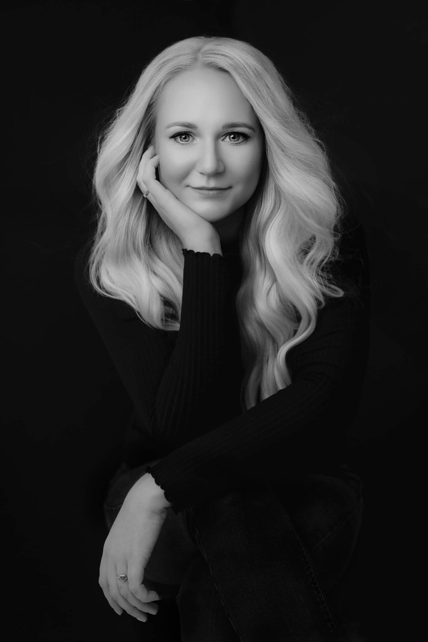 Dramatic black and white portrait series showing platinum blonde hair against dark background in artistic poses.