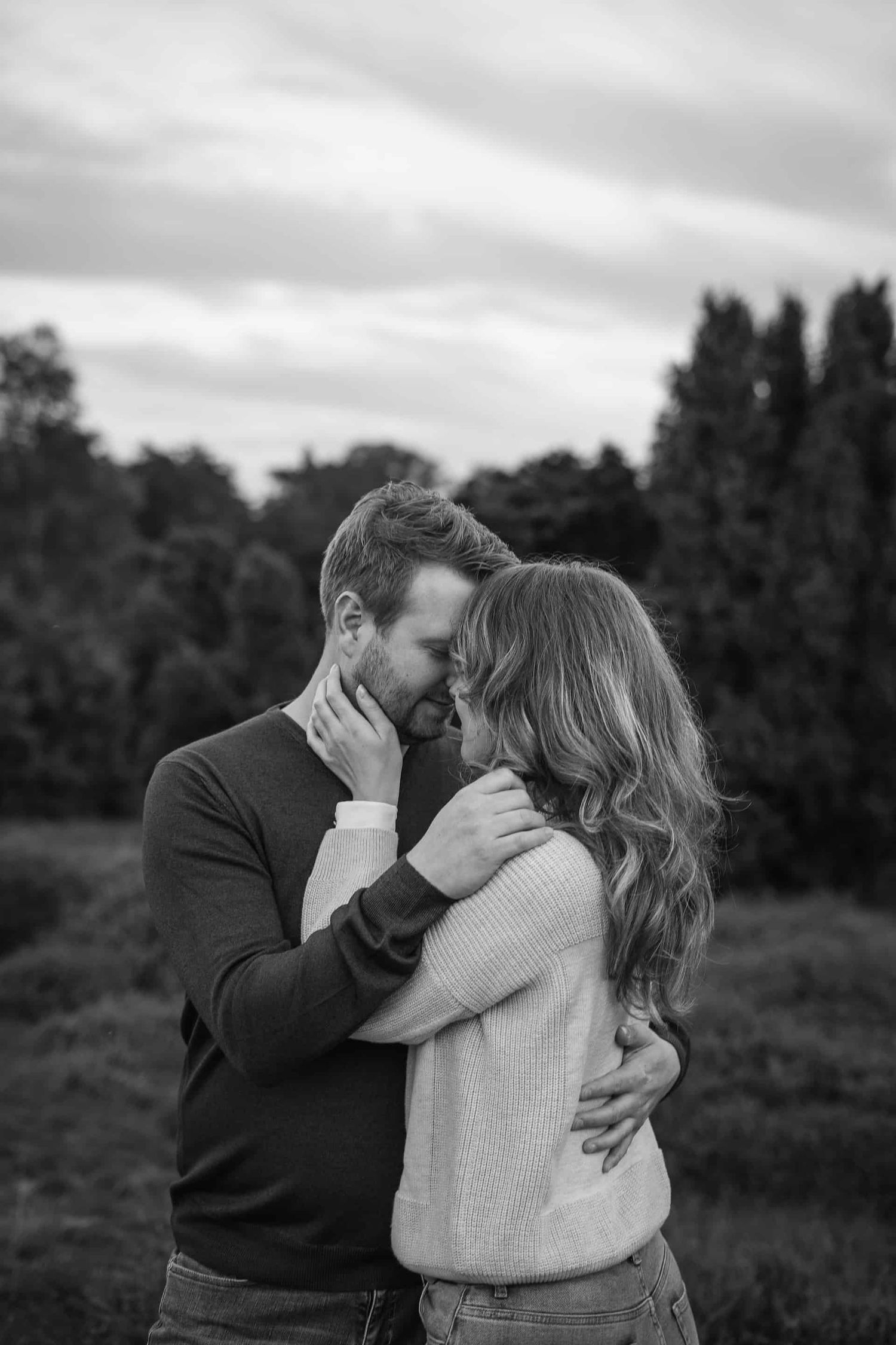 A romantic black and white photo sequence shows a couple in a cozy sweater embrace against a nature backdrop.