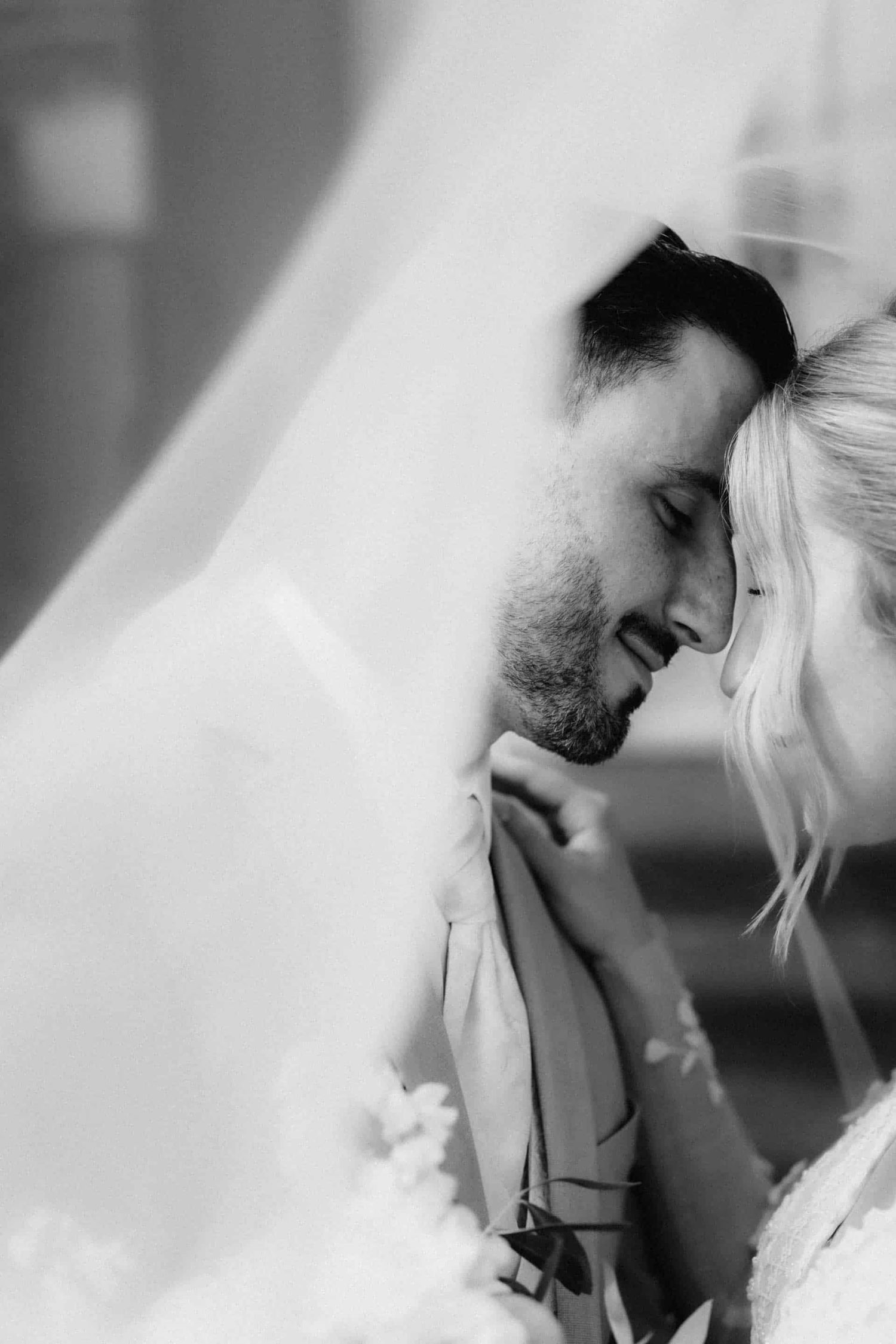 A romantic black and white photo series showing intimate moments between a bride and groom on their wedding day.