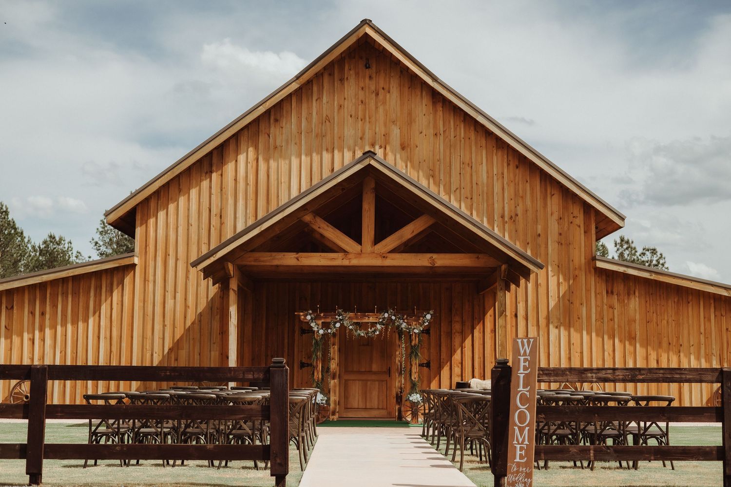 A rustic wooden barn venue with exposed beams and elegant lighting displayed from six different exterior angles.