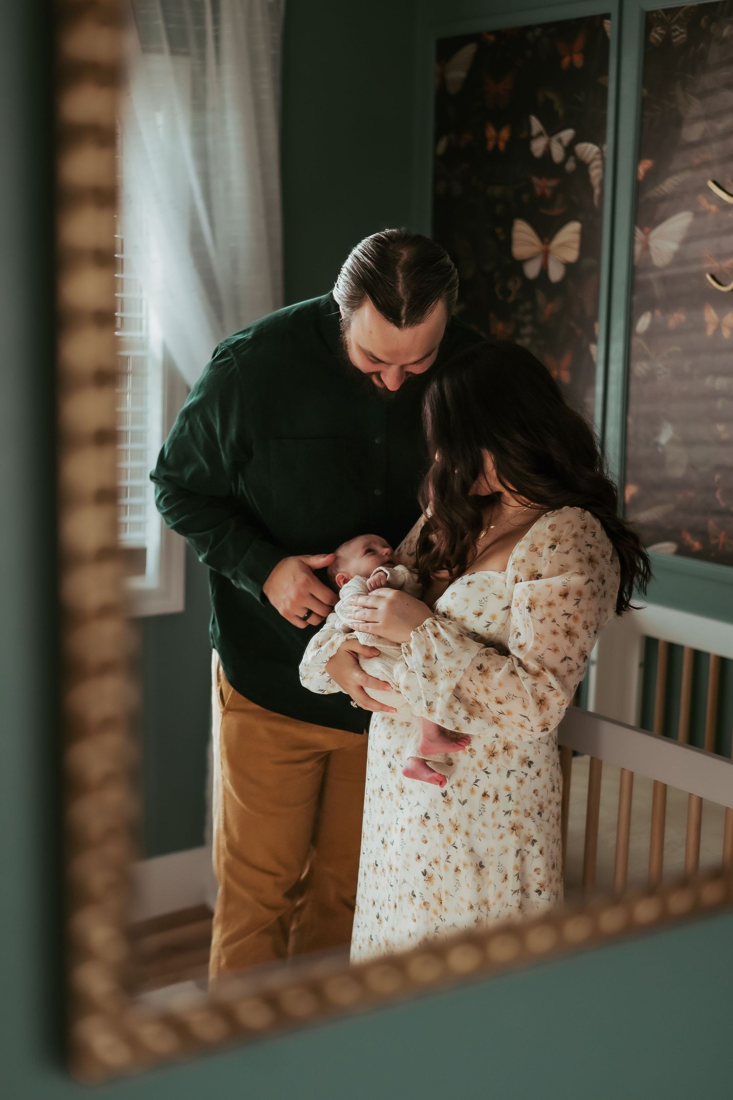 A couple shares an intimate moment on their porch in moody lighting with a natural, cozy aesthetic.
