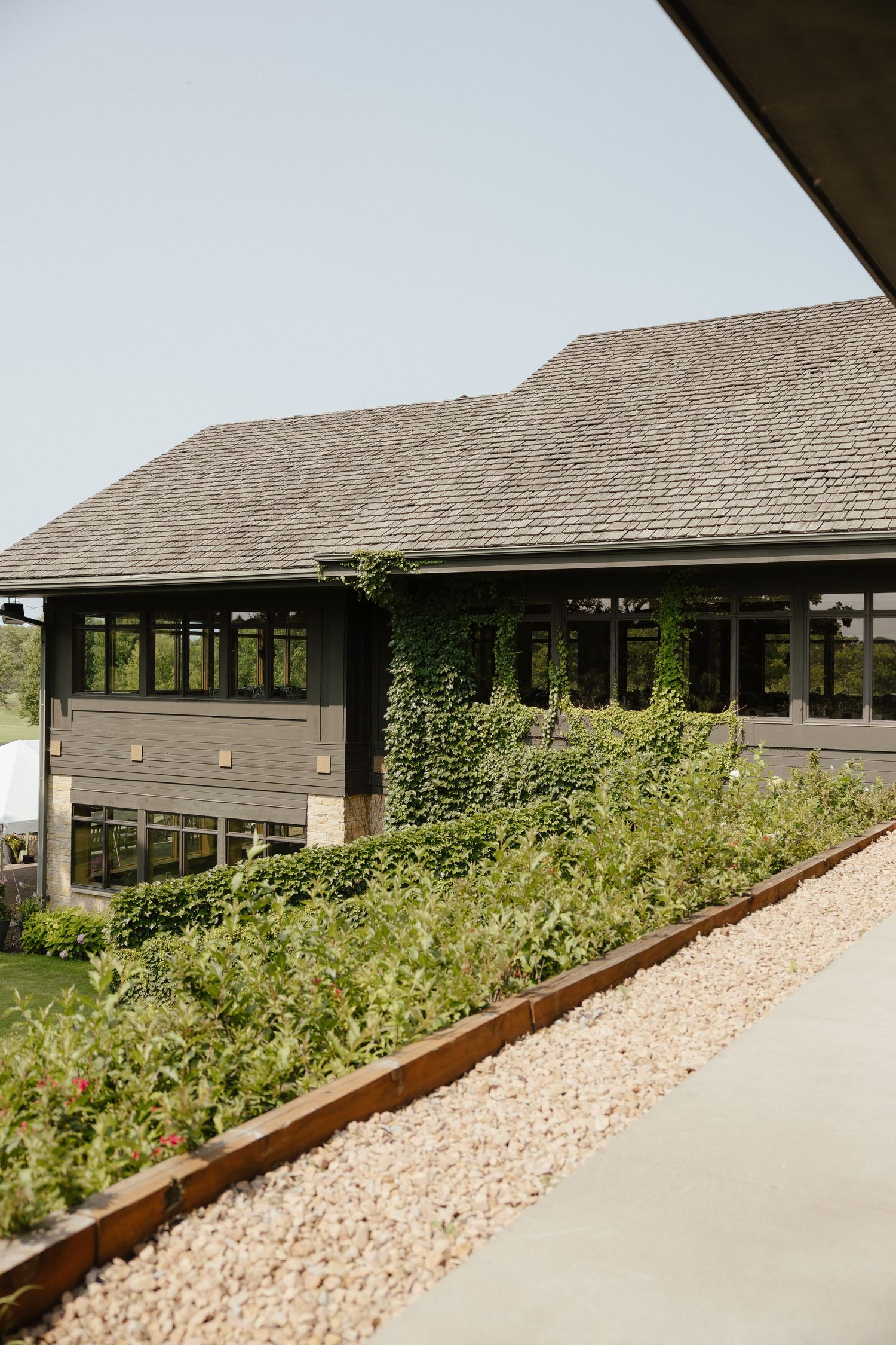 Charming golf club venue exterior with ivy-covered walls and manicured landscaping.