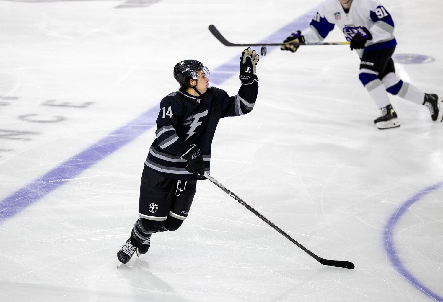 Hockey player number 14 celebrating a goal on the ice during a professional hockey game.