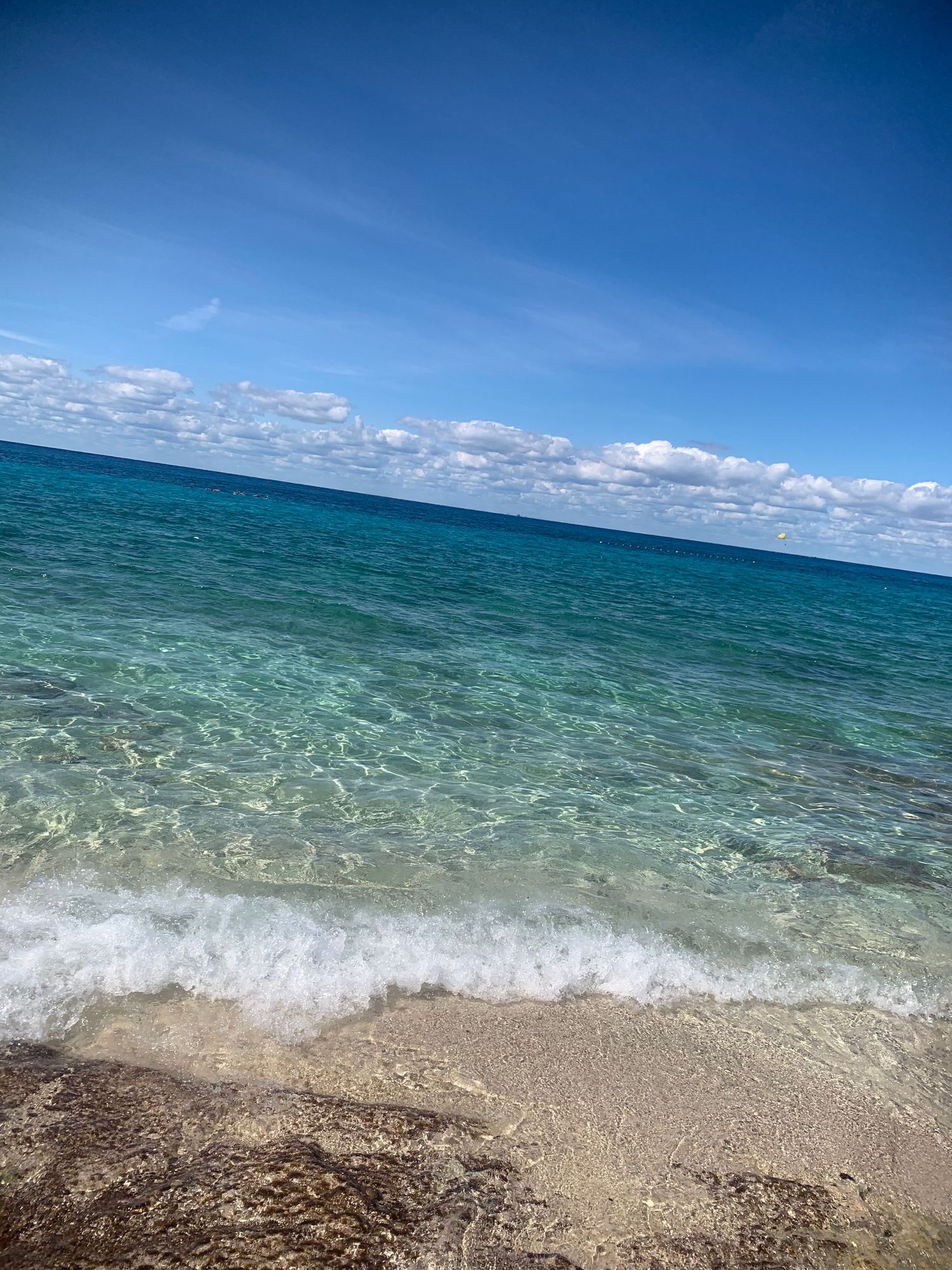 Peaceful ocean shoreline with clear blue water and sky