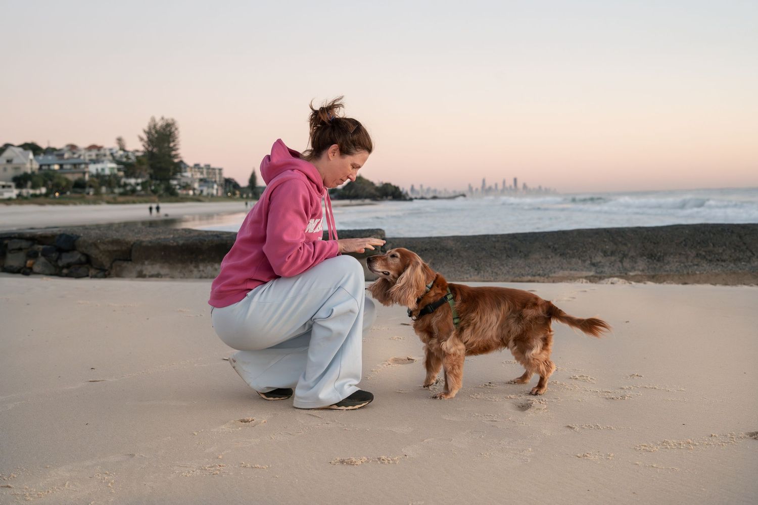 Woman with her dog on the beach during a natural pet photography session on the Gold Coast