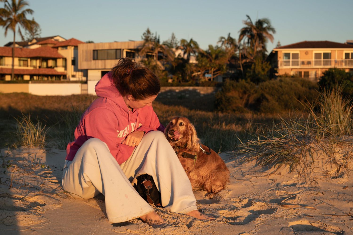 Woman with her dog on the beach during a natural pet photography session on the Gold Coast