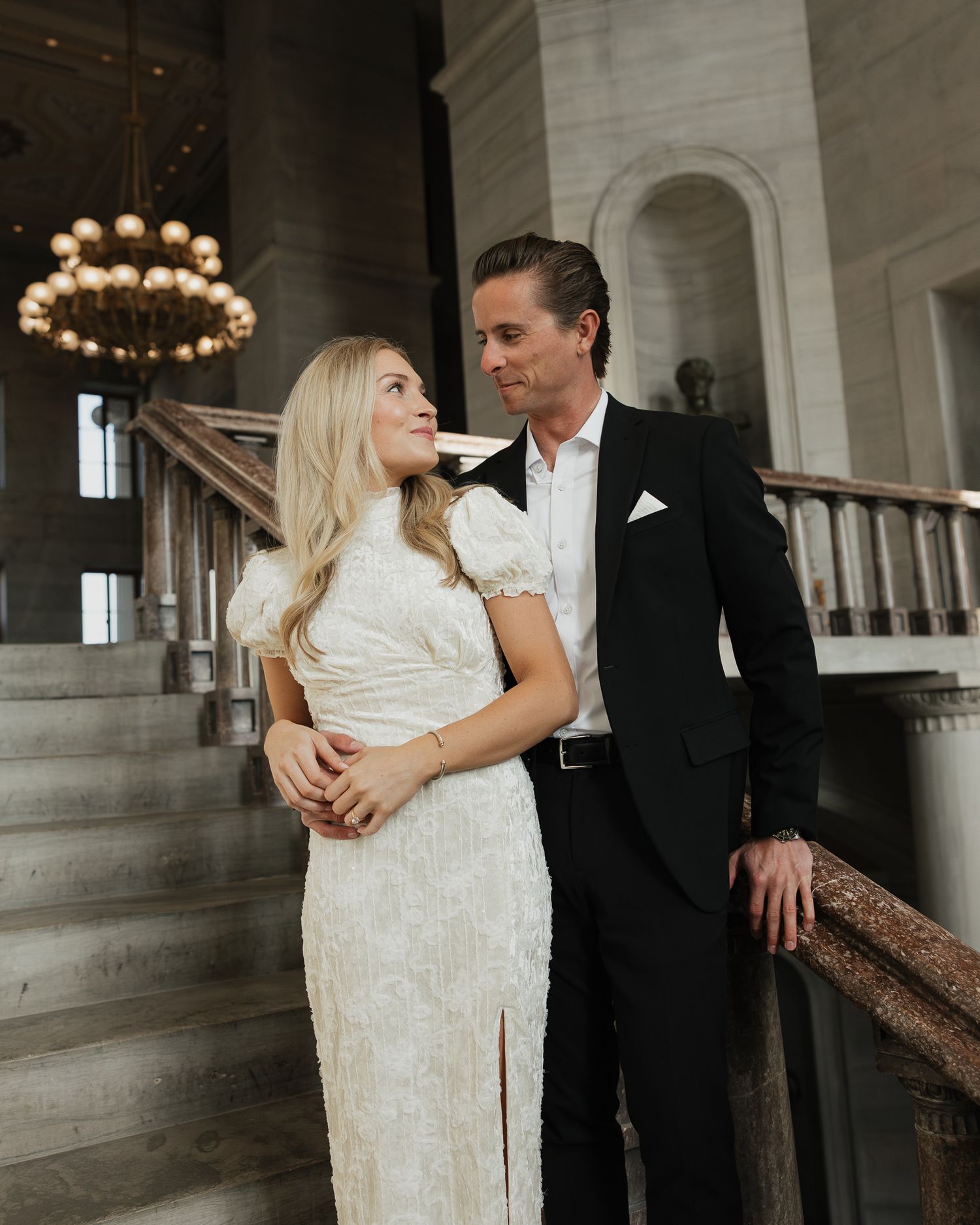 Man and woman share intimate moments in an elegant venue with grand architecture and warm lighting for engagement photos in Nashville TN