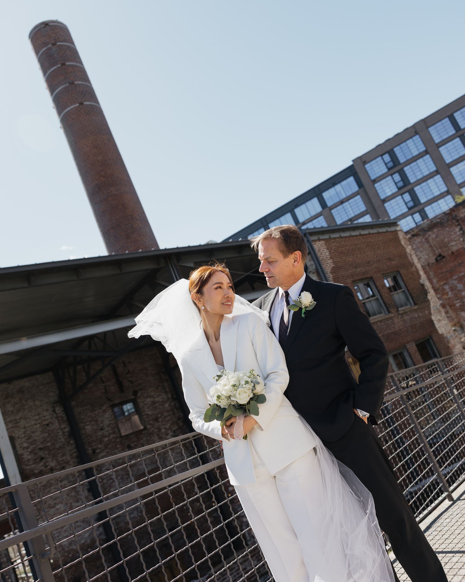 A bride and groom share a romantic moment outdoors near an industrial brick building on their wedding day in Nashville Tennessee.